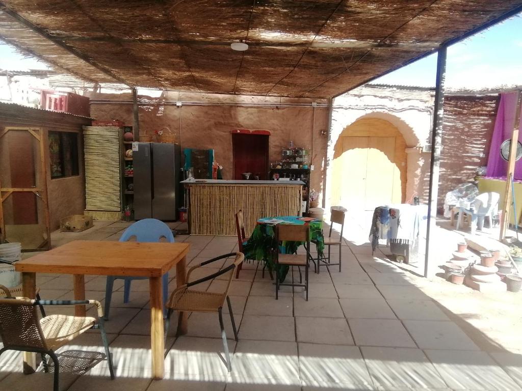 uma cozinha com mesas e cadeiras num quarto em Viajes & Vida km0 em San Pedro de Atacama