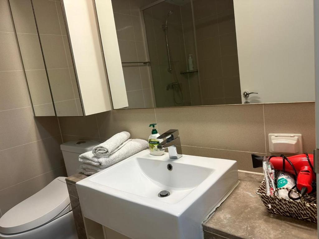a bathroom with a sink and a toilet and a mirror at Апартаменты в Хайвилл in Astana