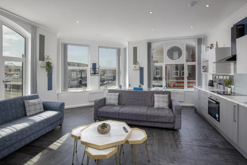 a living room with two couches and a table at South Pier Apartments by Sasco in Blackpool