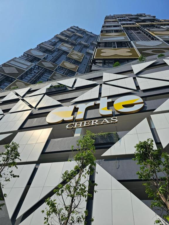 a tall building with a sign on the side of it at Arte Cheras The Premium Suites by iLuxHome in Kuala Lumpur