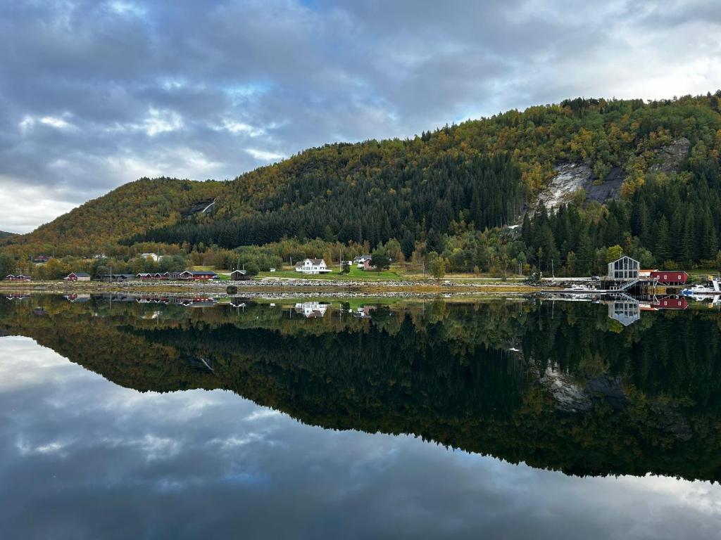 a reflection of a mountain in a body of water at Nordic Waterside Escape in Ulvsvåg