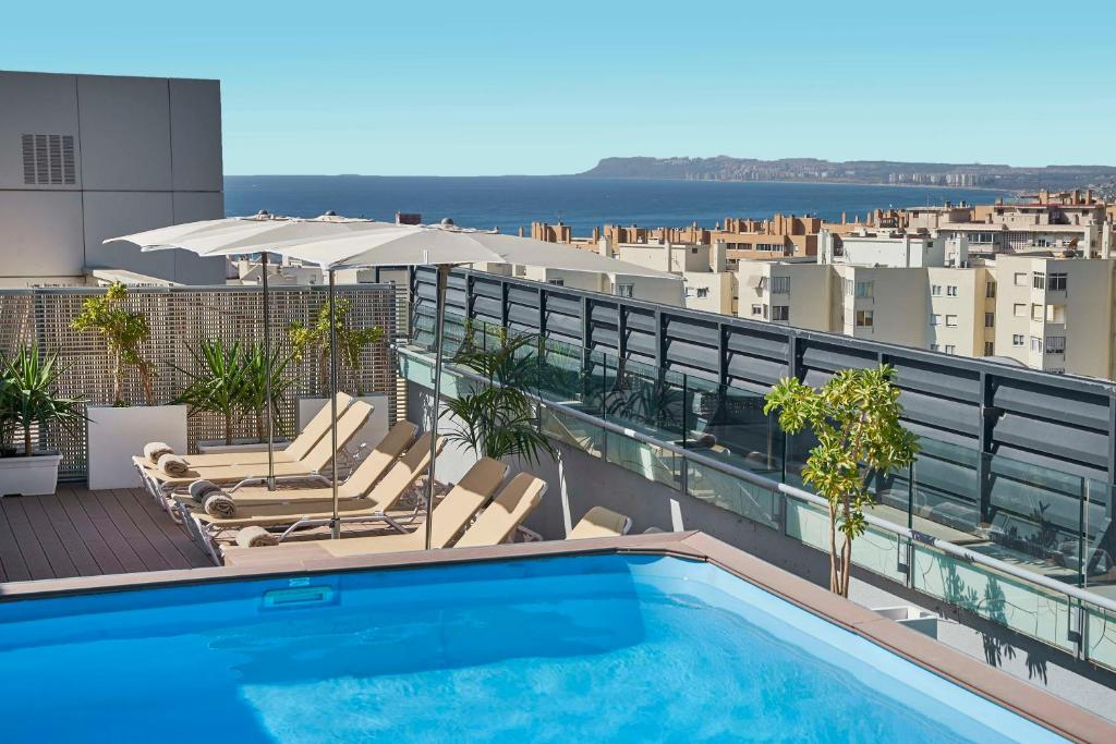 a swimming pool on the roof of a building at NH Alicante in Alicante