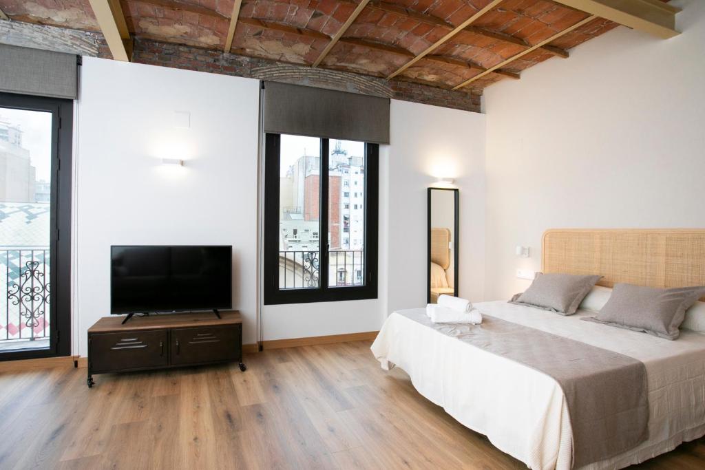 um quarto com uma cama e uma televisão de ecrã plano em Tgna Reding 22 em Tarragona