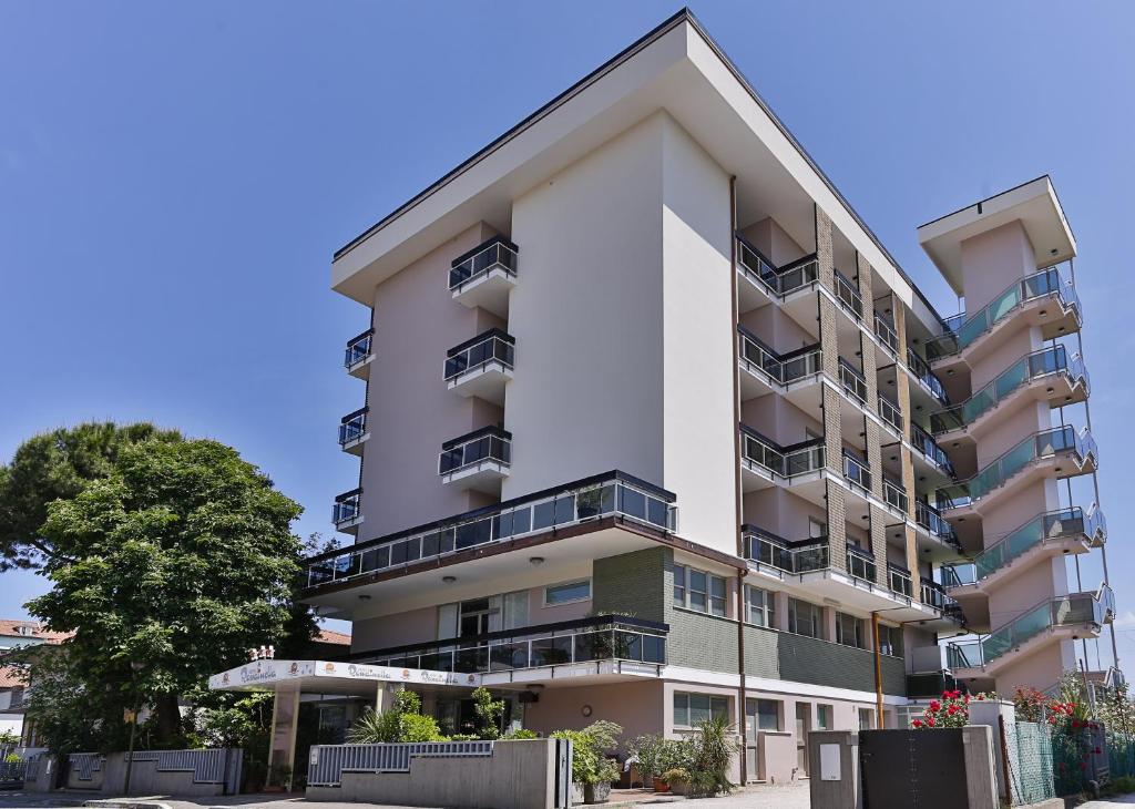 um edifício de apartamentos com varandas numa rua em Hotel Rondinella em Cesenatico