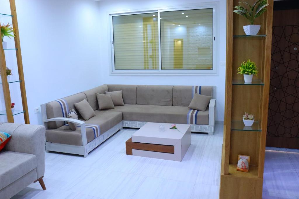 a living room with a couch and a coffee table at séjournez auprès de toutes les commodités in Sousse