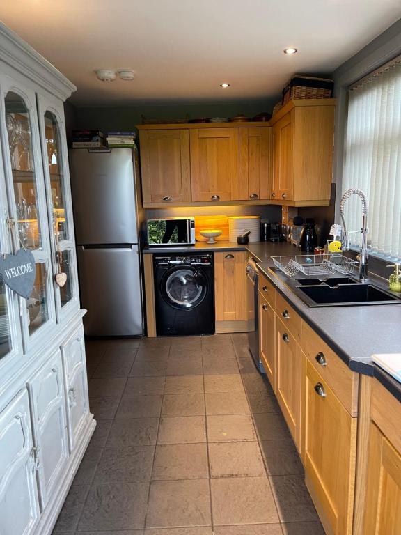 a kitchen with a refrigerator and a dishwasher at Woodend Cottage in Dumfries