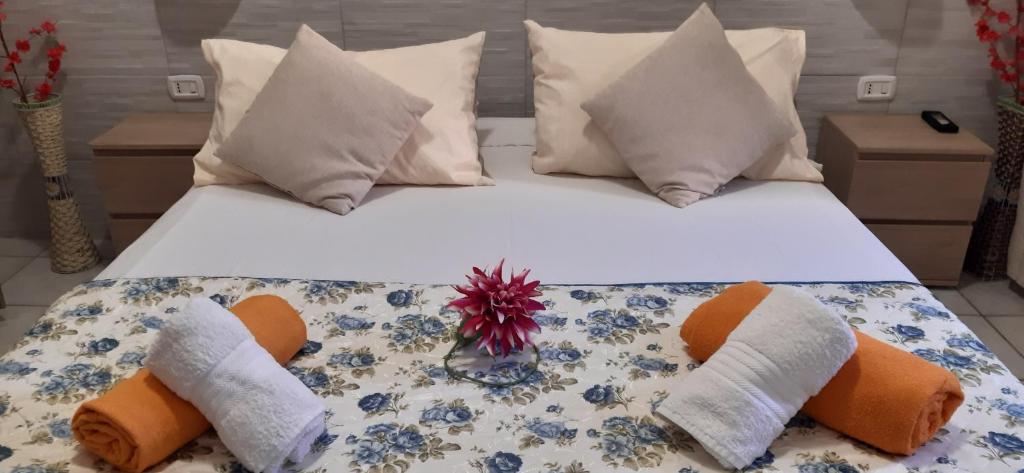 a large white bed with pillows and a flower on it at Pan di Zucchero in Iglesias