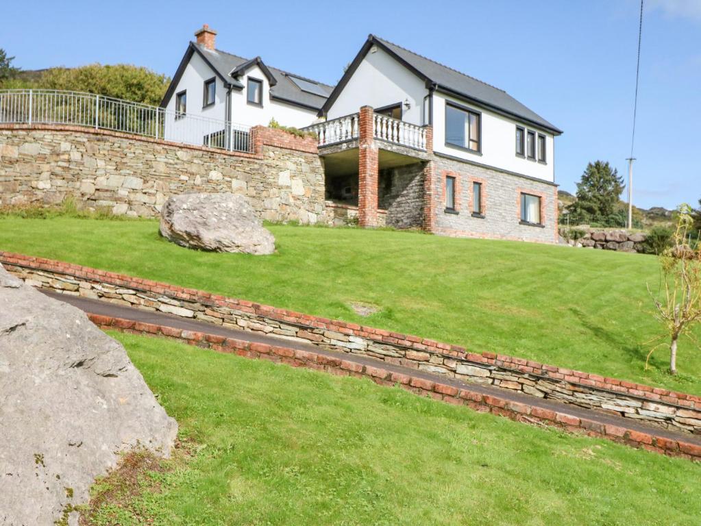 a house with a stone wall and a yard at Ocean View in Adrigole