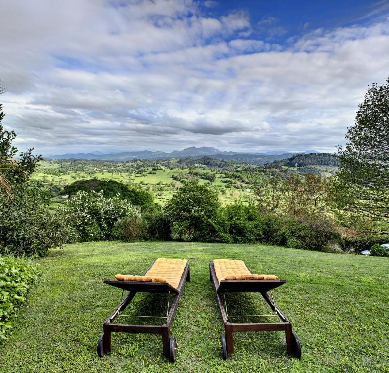 dos mesas de picnic sentadas sobre un campo en Hotel El Mirador de Ordiales, en Careses