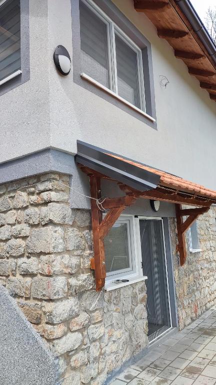 - un bâtiment avec une fenêtre et un mur en pierre dans l'établissement Apartmani Bogdanovic Studio 1, à Vrdnik