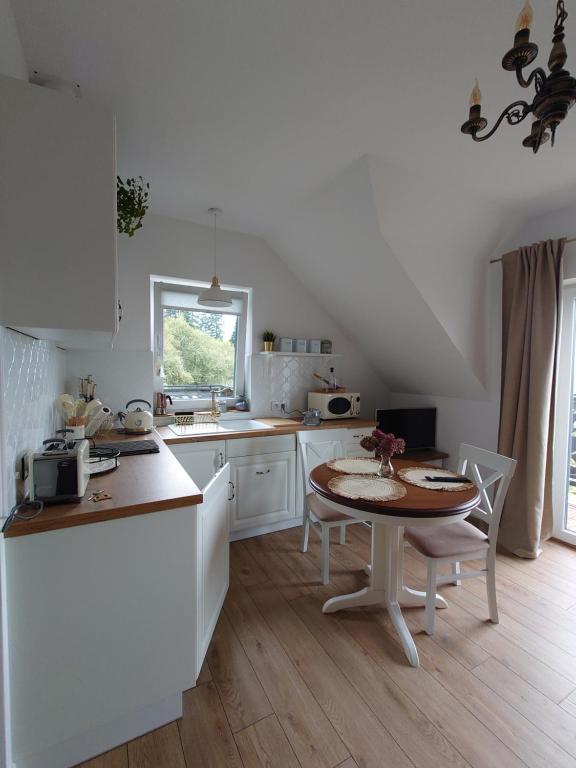 烏斯奇基的住宿－Noclegi Panorama，白色的厨房配有桌子和桌椅