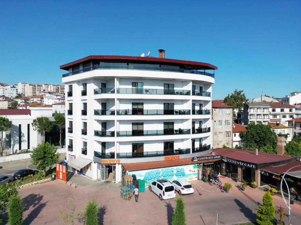 a white building with cars parked in a parking lot at Ceneviz Suit Hotel in Akçakoca