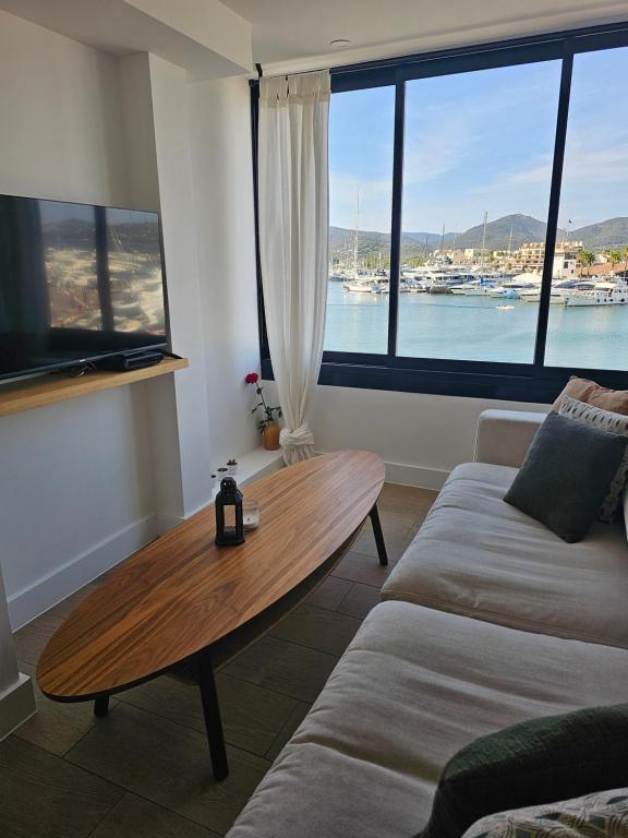 a living room with a coffee table and a large window at Très grand deux pièces Marines de Cogolin in Cogolin