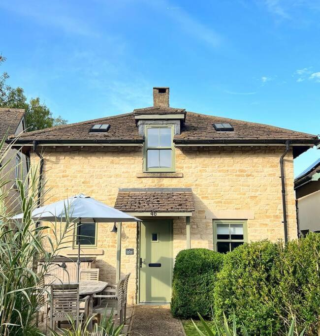 a house with a table and chairs in front of it at Cosy Cotswold Cottage - Jacobs Cottage in Cirencester