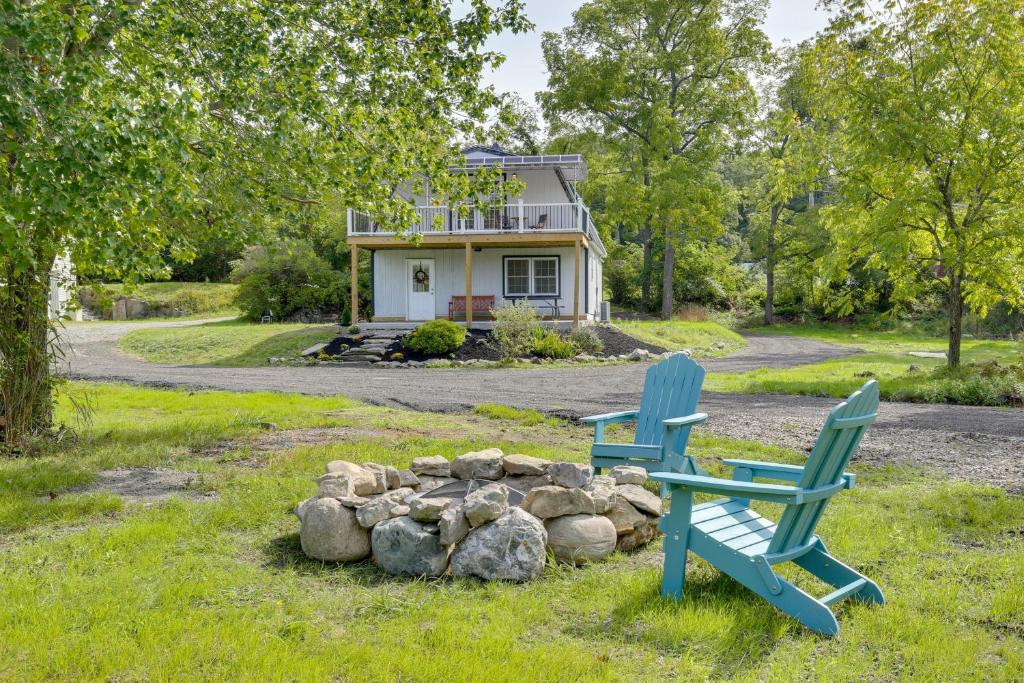two blue chairs sitting in the grass in front of a house at Fire Pit and On-Site Pond Hudson Valley Home! in Wappingers Falls