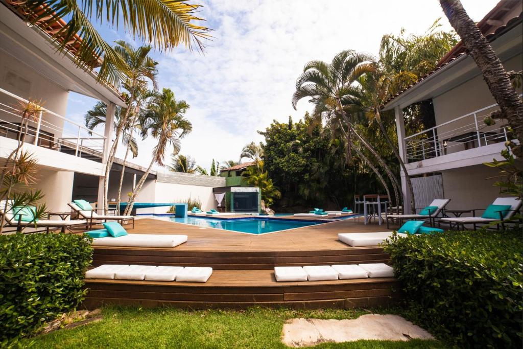 a backyard with a pool and a resort at Armação dos Búzios Pousada Design in Búzios