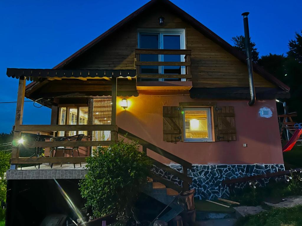 una casa con terraza por la noche en Cabana Mia Parang en Petroşani