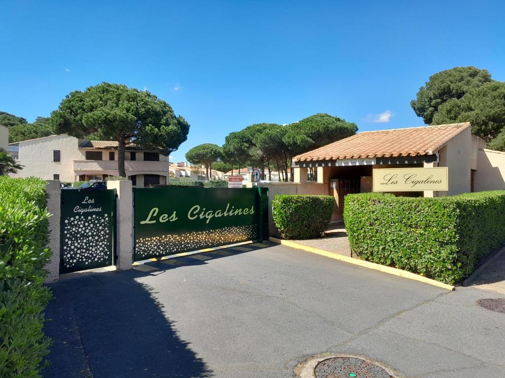 une porte menant à un panneau d'expérience perdue dans un parc dans l'établissement Maison au calme de la pinède, piscine, plage et farniente, au Cap d'Agde