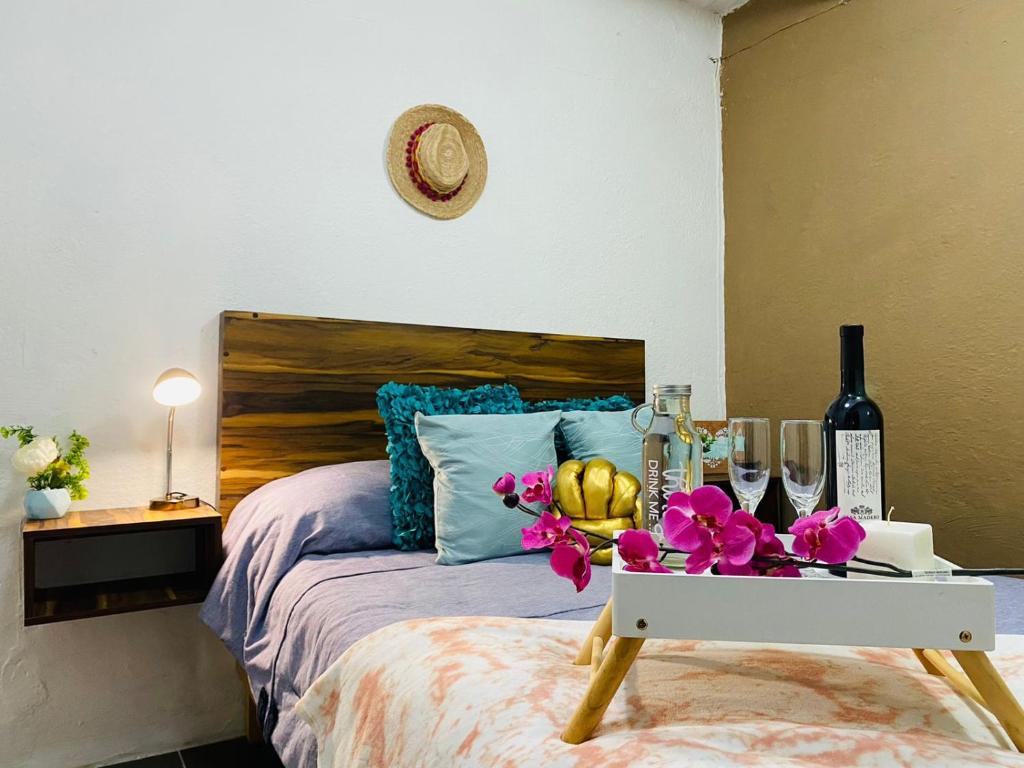 a bedroom with a bed with a table with flowers at Departamento centrico - Bufa House in Guanajuato