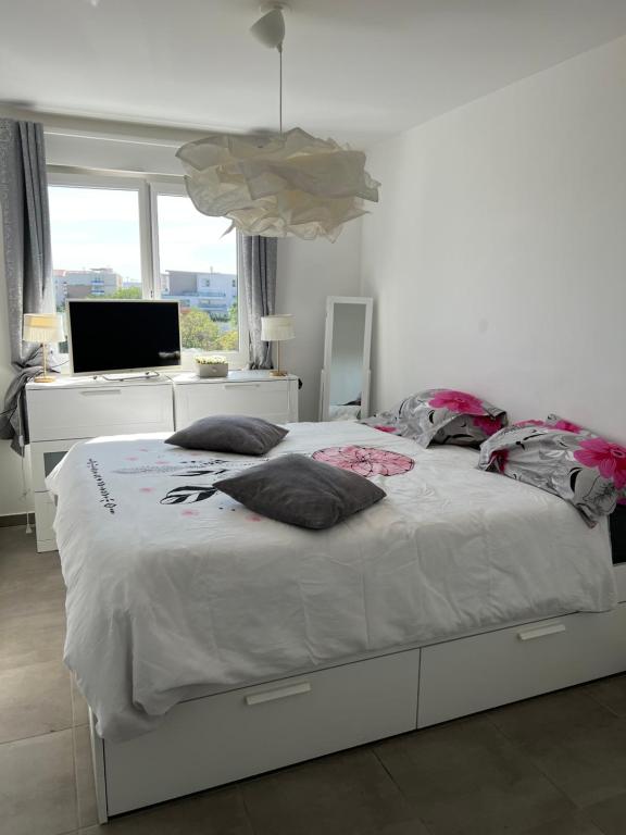 sypialnia z dużym białym łóżkiem z poduszkami w obiekcie Chez moi à côté du Groupama stadium w mieście Décines-Charpieu