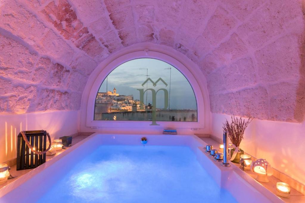 a bath tub in a pink room with a window at Dimora Matteotti by Meravigliosa Puglia RealEstate in Ostuni