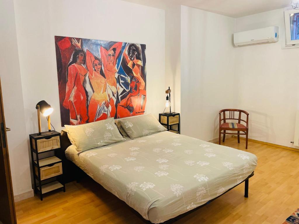 a bedroom with a bed with a painting on the wall at Accogliente Appartamento Spazioso in Grosseto