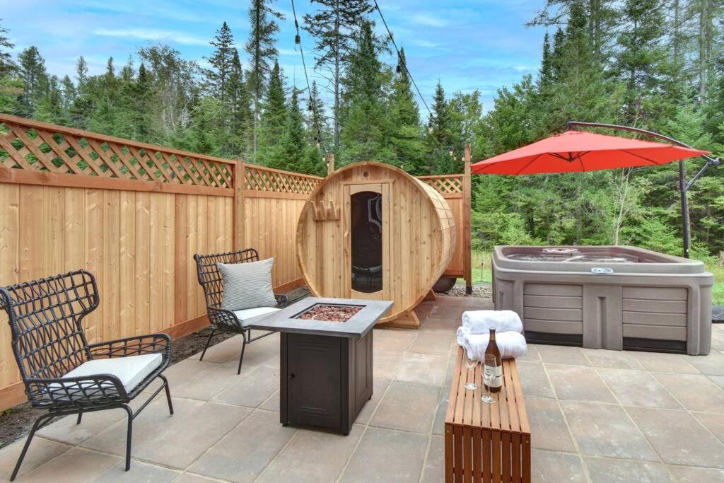 a patio with a hot tub and a gazebo at Chalet SPA SAUNA Tremblant in Saint-Faustin