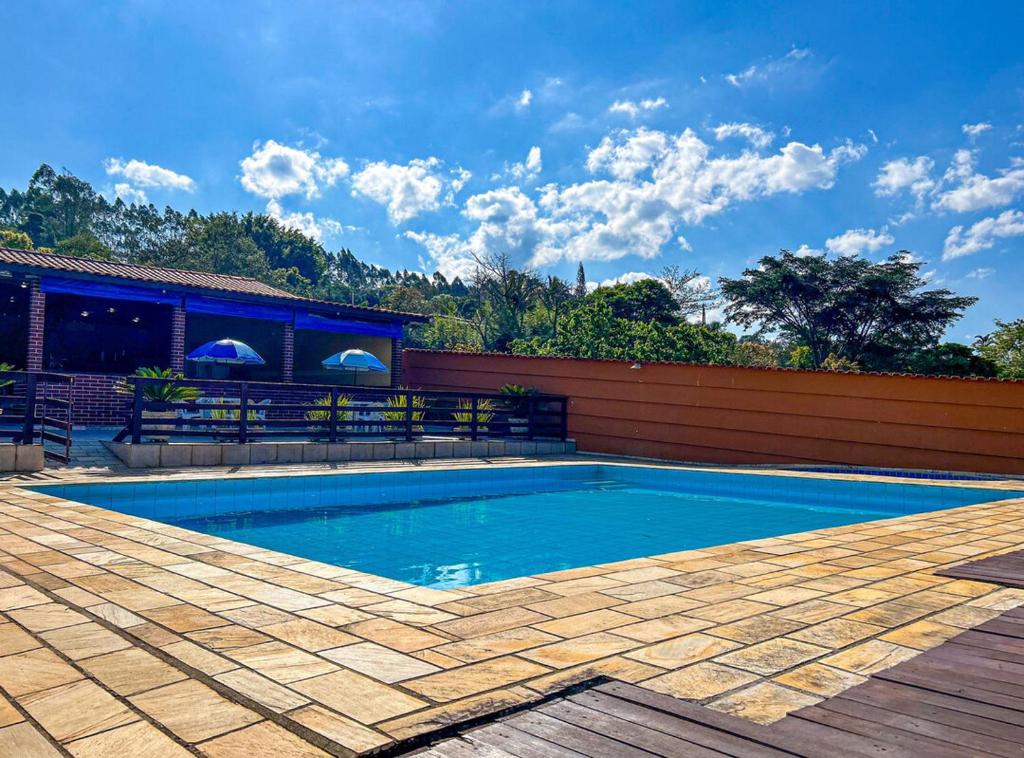 瓜拉雷馬的住宿－Chacara com Wi-Fi e muito lazer em Guararema SP，后院的游泳池,设有木甲板