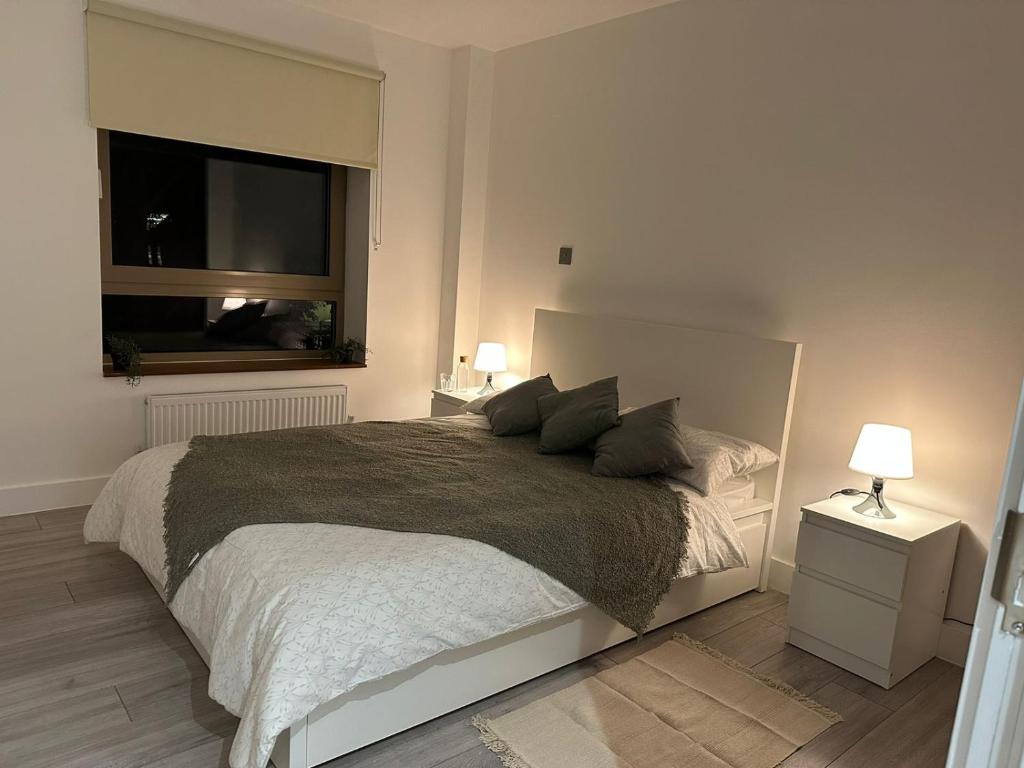 a bedroom with a large bed and a window at Kensington House by Solitaire Suites in Slough