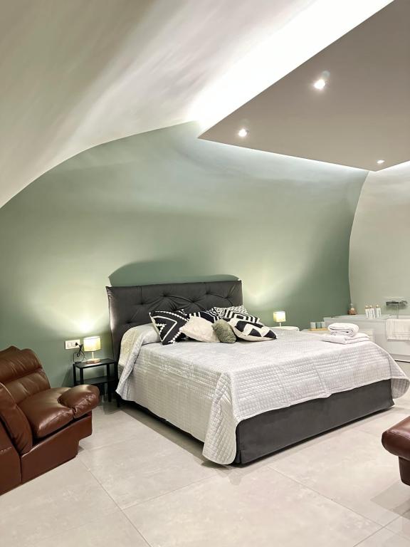 - une chambre avec un grand lit et une chaise dans l'établissement CARMA SUITE, à Naples