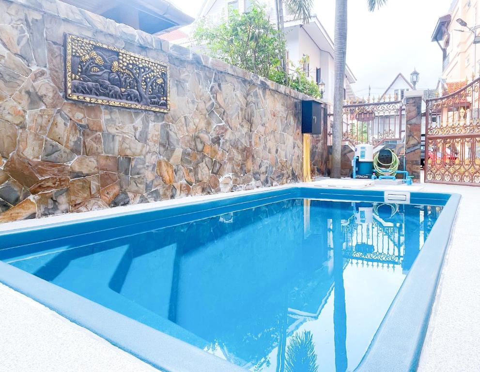 a swimming pool in front of a stone wall at Patong Beach - Private Pool Villa in Patong Beach