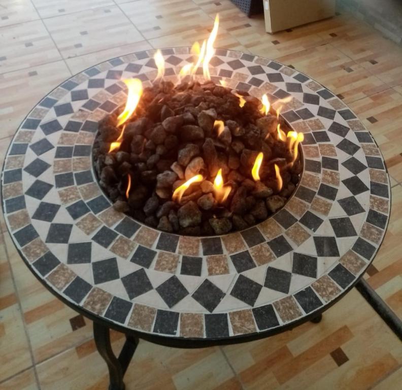 un focolare con fiamme su una scacchiera di Fig House Villa with Heated Swimming Pool & Firepit ad Al ‘Aqar