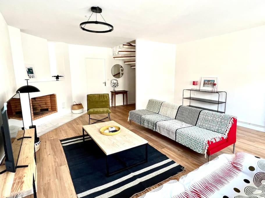 uma sala de estar com um sofá e uma mesa em Superbe appartement avec parking em La Rochelle
