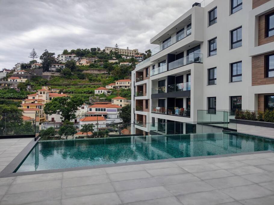 a large building with a swimming pool in front of it at Happy Uptown 13 in Funchal