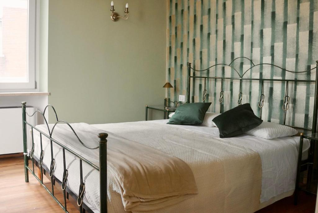 a bedroom with a large bed with green pillows at Domus 44 Rooms - Porta Nuova in Verona