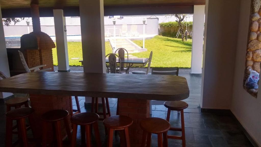 a table and stools in a room with a patio at Casa para finais de semana temporada in Caraguatatuba