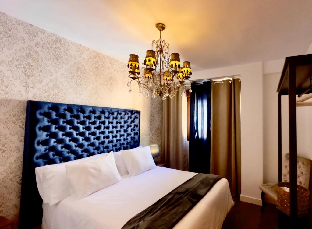 - une chambre avec un grand lit et un lustre dans l'établissement Libelle Andalusian Hideaway C, à Grenade