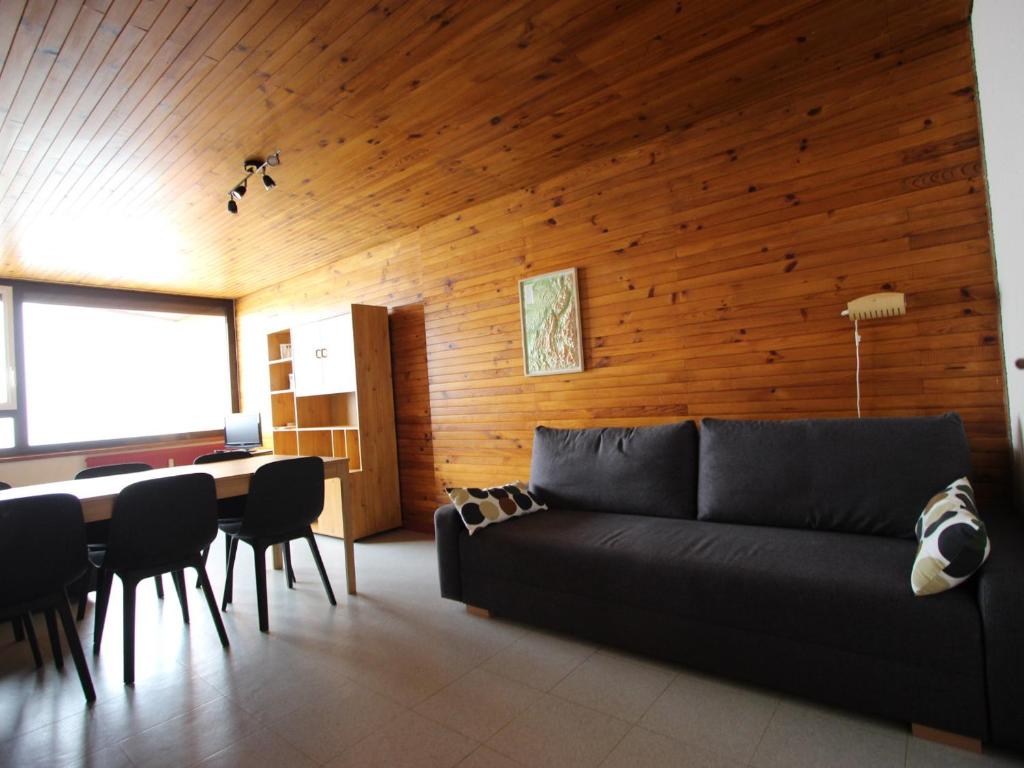 a living room with a black couch and a table at Appartement Chamrousse, 2 pièces, 6 personnes - FR-1-549-109 in Chamrousse