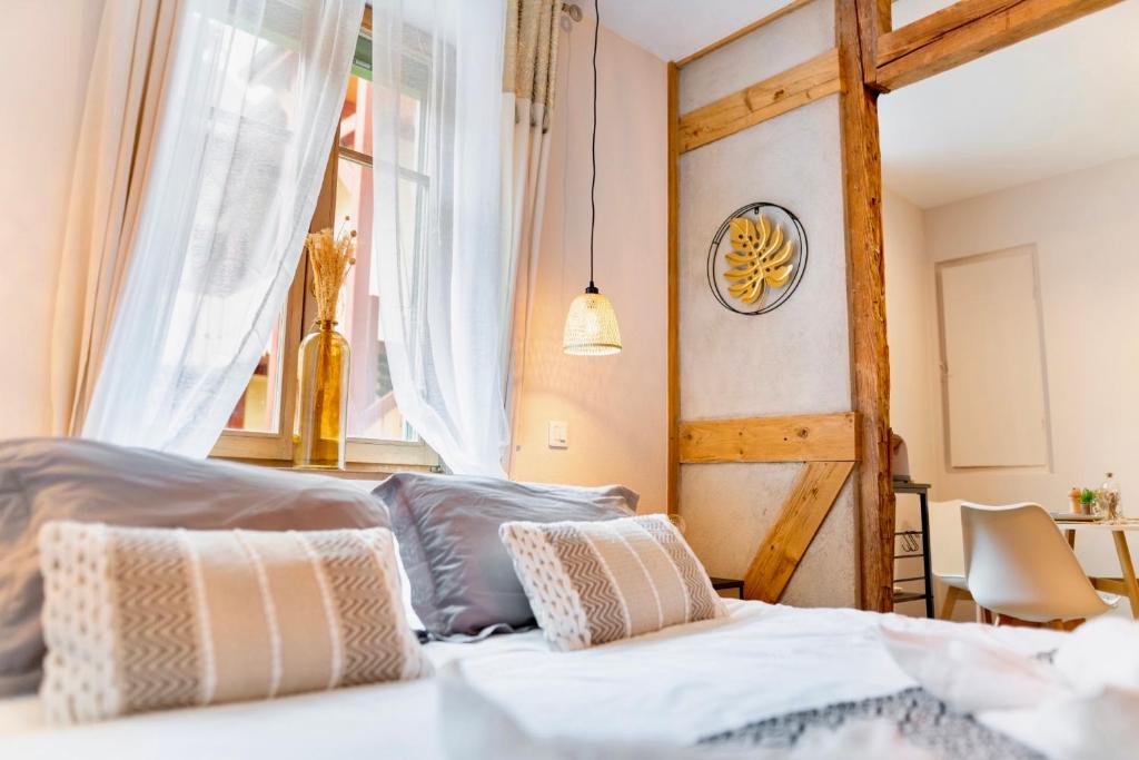 a bedroom with a bed and a window at Au Petit Lion, Colmar centre Garage gratuit in Colmar