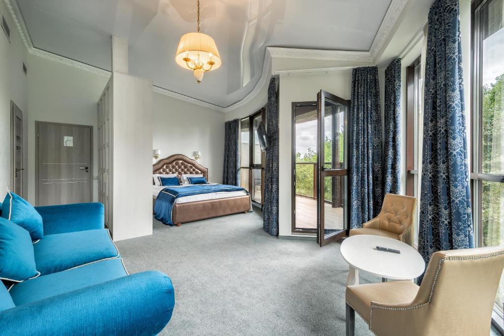 een hotelkamer met een blauwe bank en een bed bij Župė De Lux in Radailiai