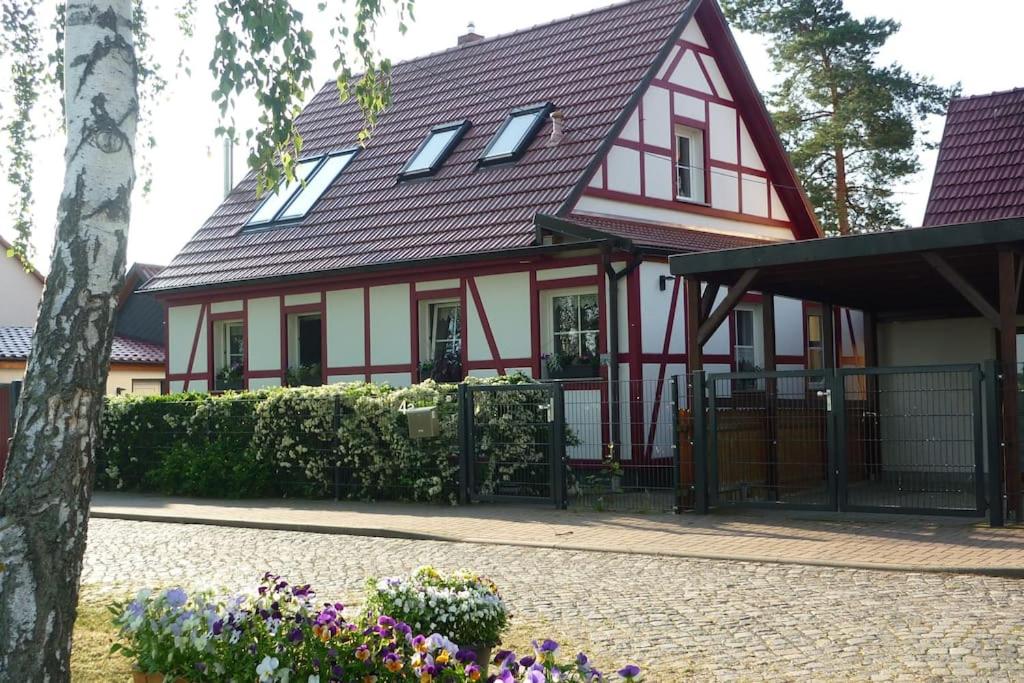 a red and white house with flowers in front of it at Erpelhaus in Utzberg