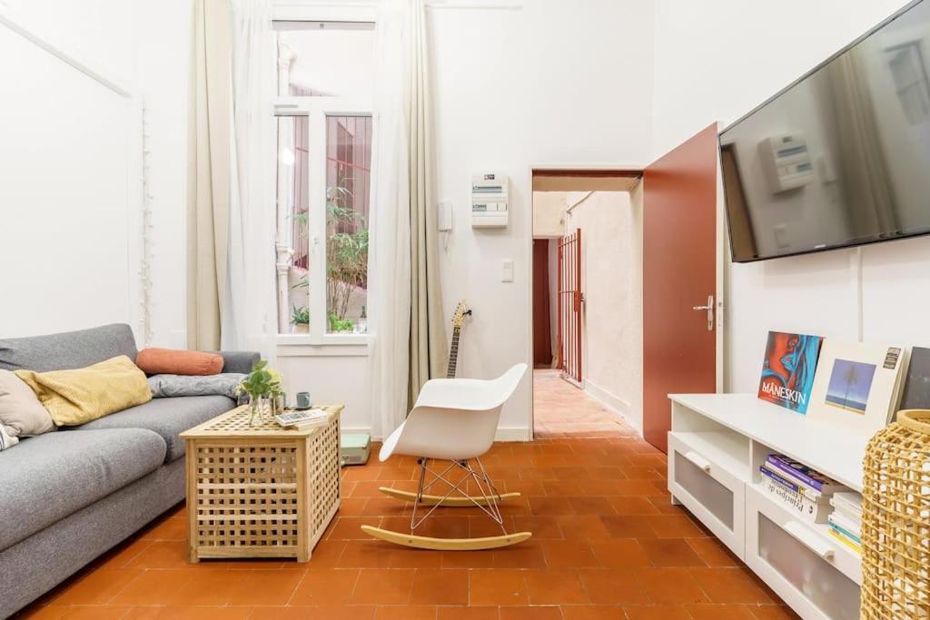 een woonkamer met een bank en een stoel bij Duplex en plein centre historique Aix en provence in Aix-en-Provence