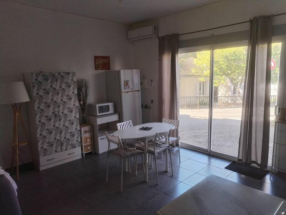 une cuisine avec une table, des chaises et un réfrigérateur dans l'établissement Studio, à Arles