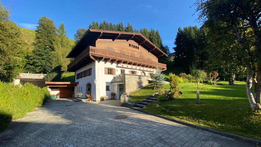 a large white house with a brown roof at Pension Hattinger in Maria Alm am Steinernen Meer