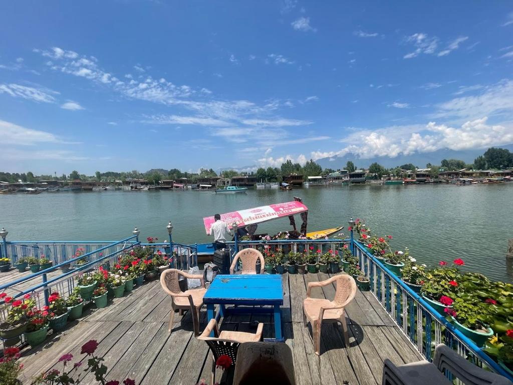 シュリーナガルにあるGulbahaar Group Of HouseBoatsのテーブルと椅子が備わる川上のボート