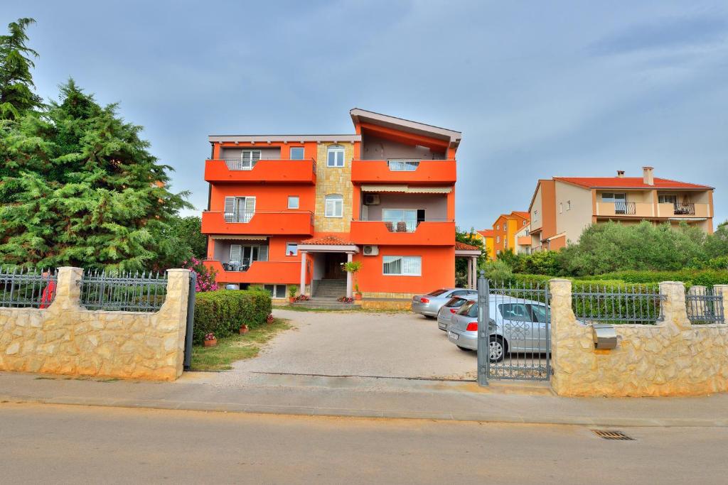 ein orangefarbenes Gebäude mit davor geparkt in der Unterkunft L&L Holiday Apartment in Zadar