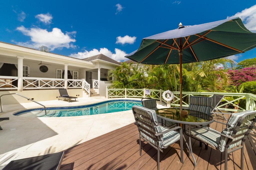 a patio with a table and chairs and an umbrella at Hullabaloo in Saint James