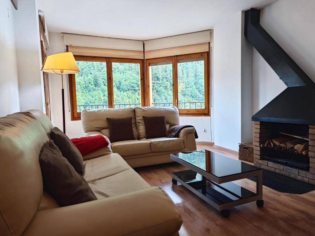 uma sala de estar com um sofá e uma lareira em Allotjaments Bruc em Camprodon