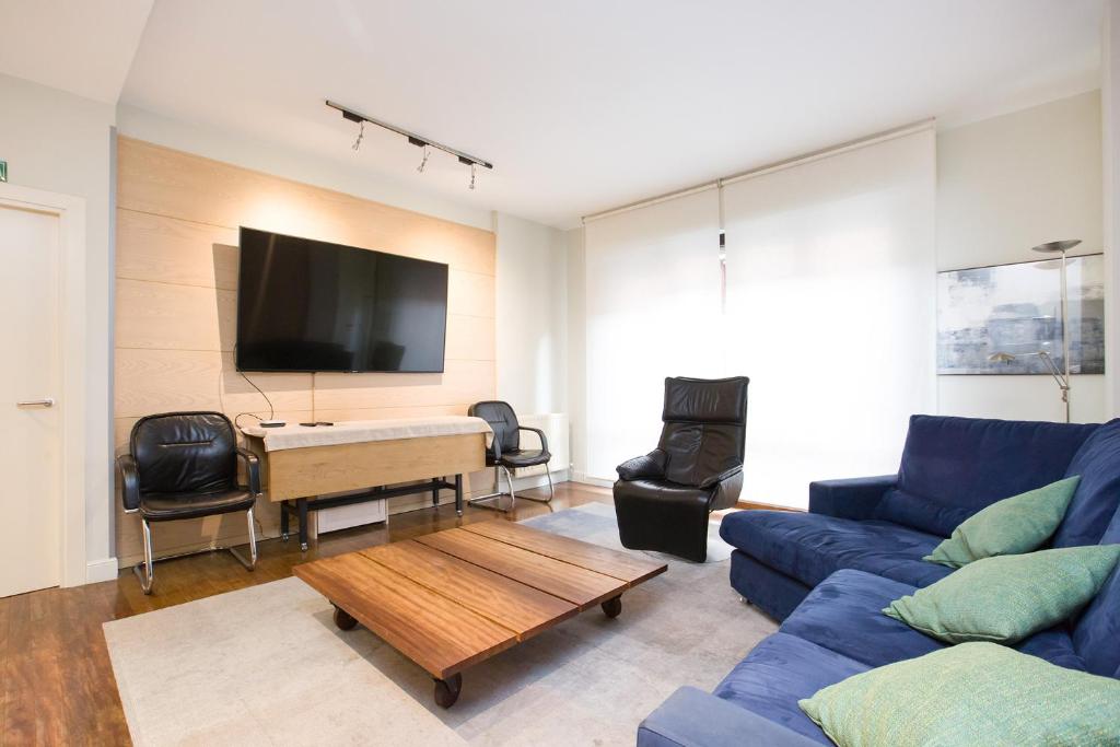 a living room with a blue couch and a table at Volantin Apartment in Bilbao