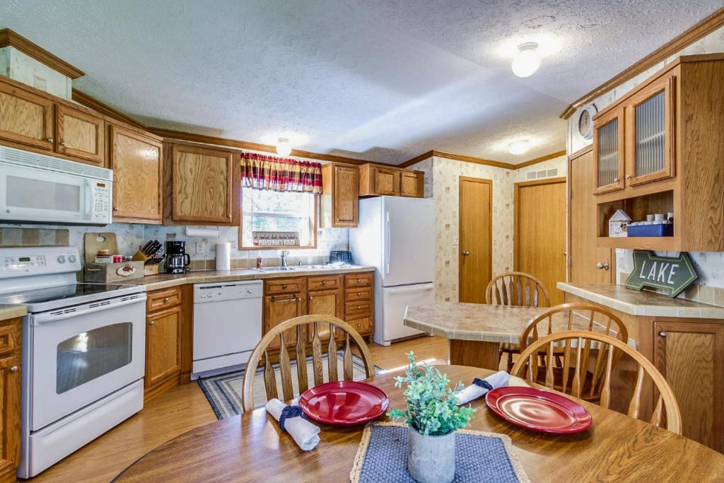 a kitchen with wooden cabinets and a table and chairs at Oak Harbor Walleye Camp in Baudette